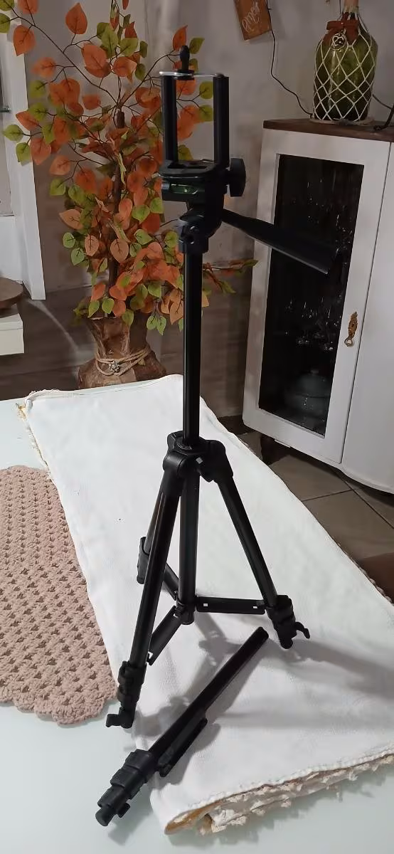 Tripé 3120 montado sobre uma mesa com suporte para celular acoplado