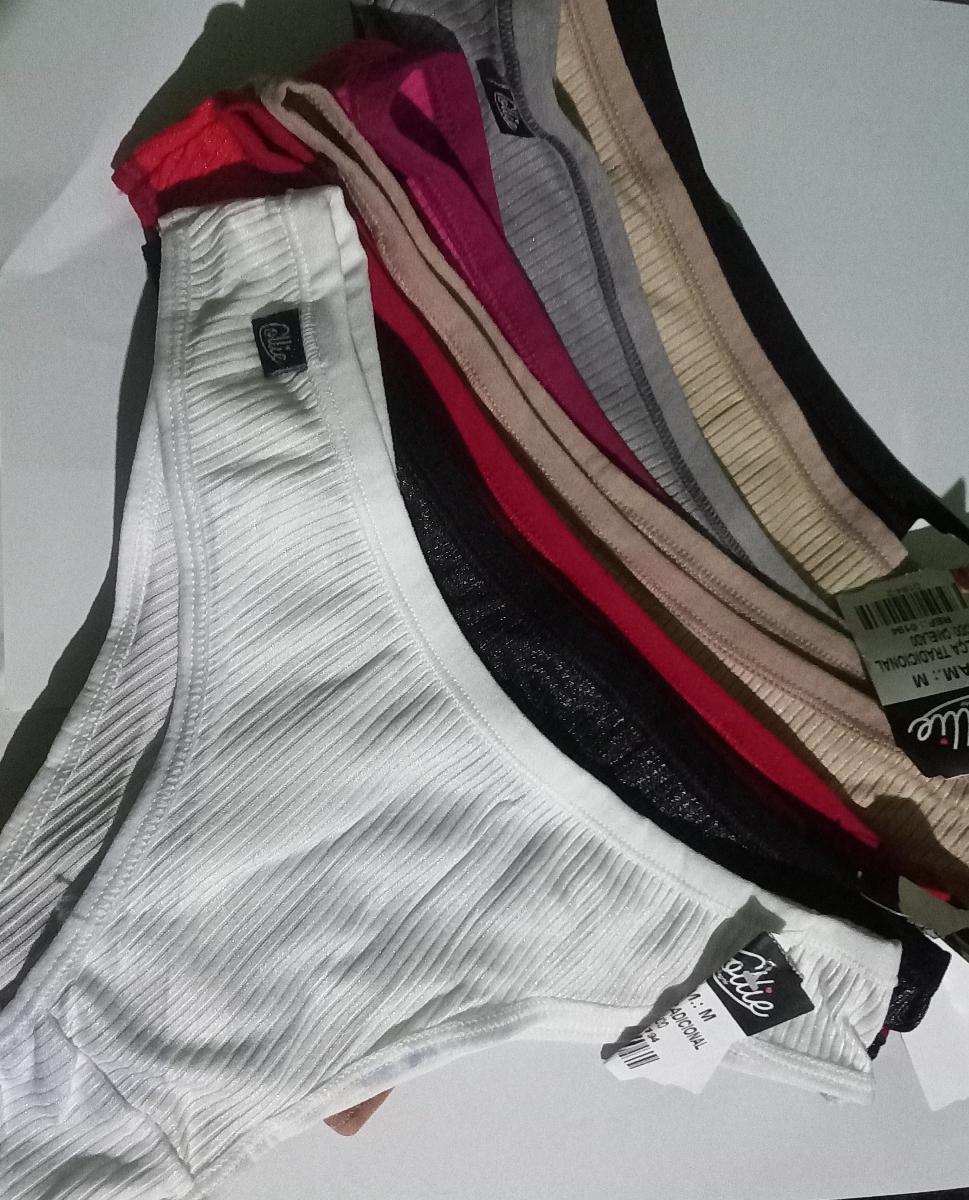 Pilha de calcinhas tanga em diversas cores incluindo branco, preto e bege com etiquetas visíveis